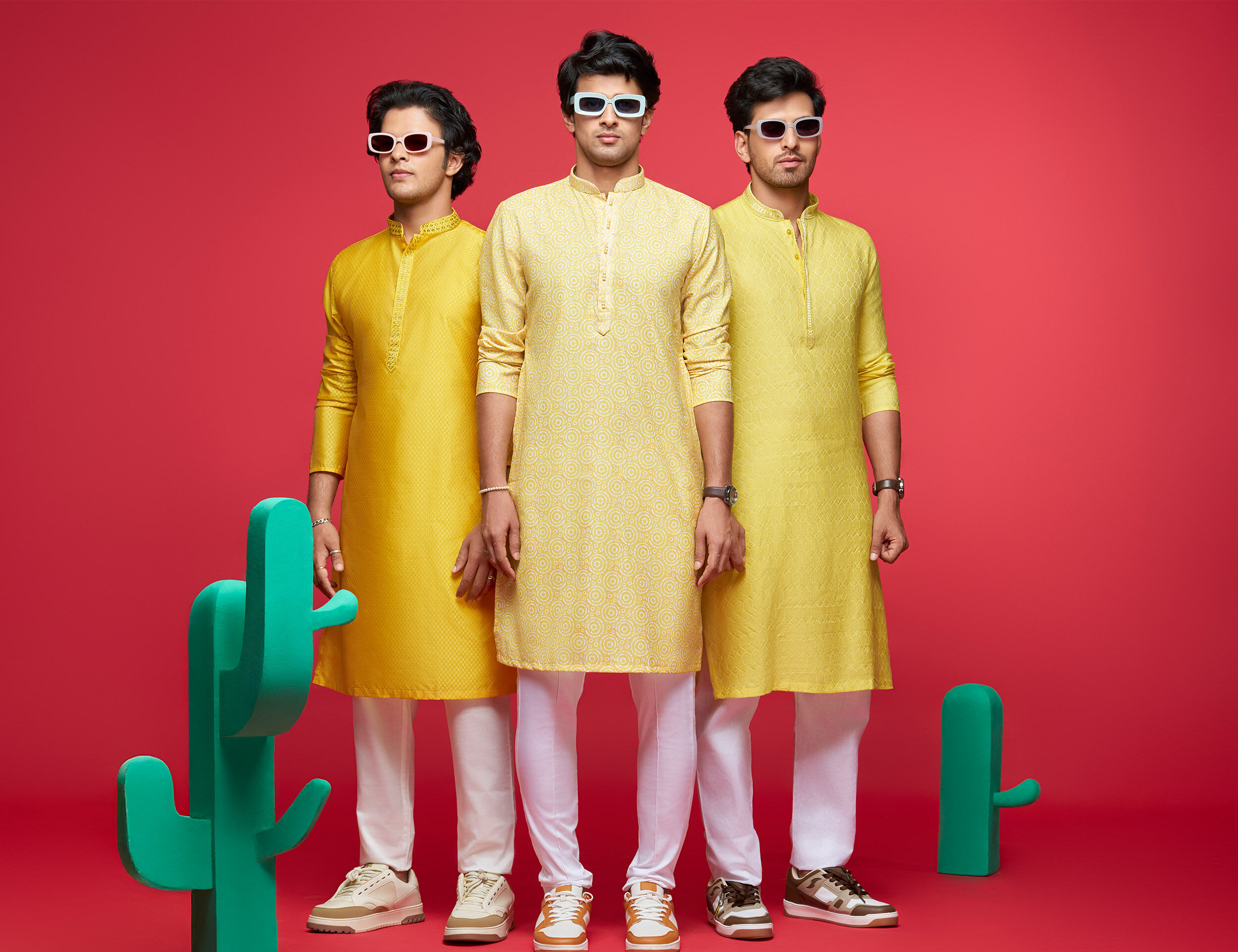 Men in stylish yellow kurtas with white trousers, showcasing modern festive kurta fashion against a colorful background.